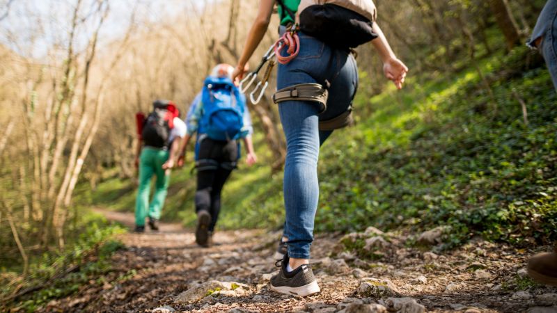 3 wanderer gehen aufwärts entlang eines berghanges