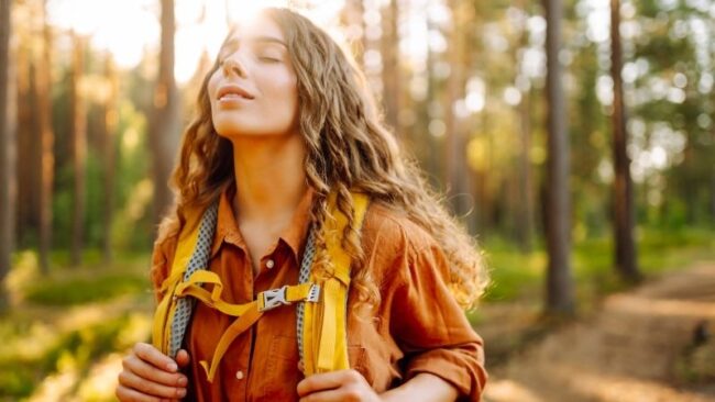 Herbstwandern ohne Beschwerden junge frau wandert durch den herbstlichen blätterwald