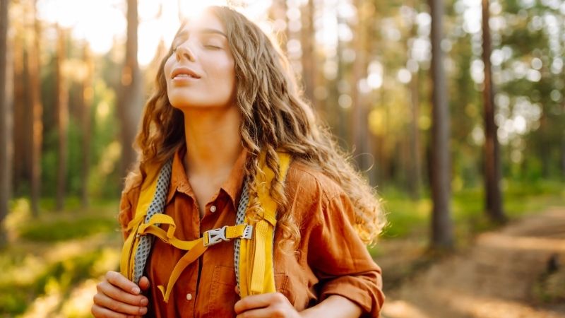 junge frau wandert durch den herbstlichen blätterwald